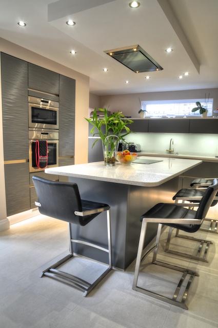 The island has room to seat 4 and incorporates an induction hob. Above is a ceiling box with lighting and Westin extractor.