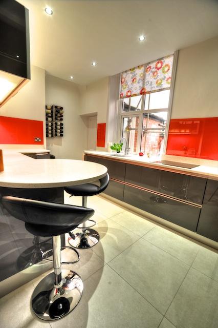 high gloss fitted kitchen with radius breakfast bar