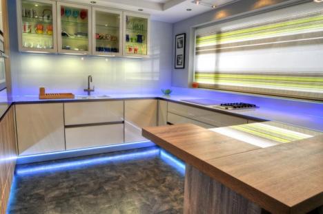 Gloss white and wood finished handleless Keller kitchen with illuminated glass wall units and glass worktops. 