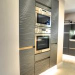 built in raised level ovens with pull out larder units either side and LED plinth lighting.