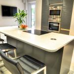 Seating side of the island with comfortably rounded worktop corners, view of TV and popup socket within easy reach.