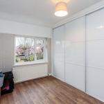 Sliding wardrobe doors with white glass panels and white metal frames.