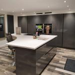 Kitchen island and tall housings in Keller basalt grey gloss with white Corian® worktop
