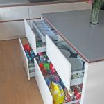 Kitchen island drawers open, showing convenient storage for cutlery, plates and groceries