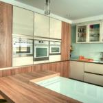 Gloss white and washed oak handleless kitchen with white glass worktops and splashbacks.