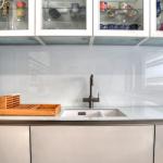 A white glass splashback matches the worktop and creates and easy-clean wet area.