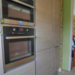 an integrated fridge freezer behind closed doors next to oven 