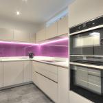 High gloss kitchen with quartzstone worktops and raised Neff ovens