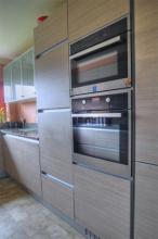 Fitted kitchen features a Kuppersbusch double oven