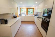 Gloss magnolia handleless Keller kitchen with CRL Quartz River White worktops and Bosch appliances